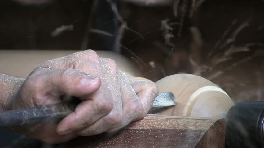 A close up shot of a man working on an old style lathe in Bangkok, Thailand.