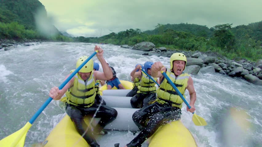 Team of six people white water rafting. On board camera.