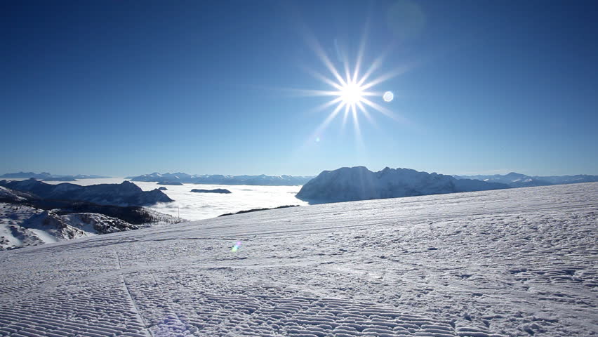 male skier carving on piste near camera at sunshine