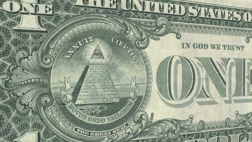 The All Seeing Eye on the back of the US Dollar Bill glows and emits rays of light as the camera draws closer.