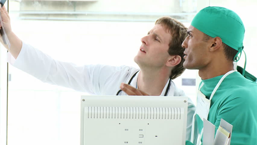 Surgeon and Doctor looking at an xray in a doctors office 