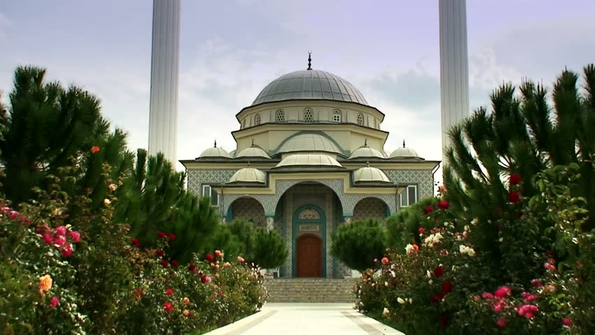 Flower filled entrance to a twin minaret Turkish mosque