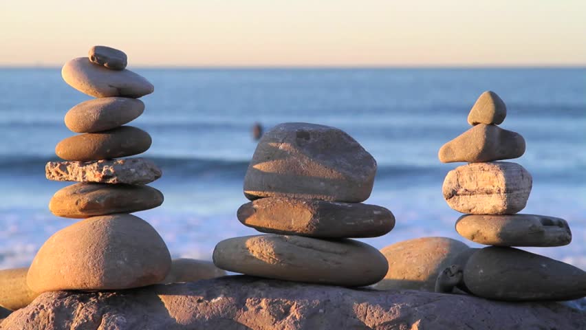 Rocks Balanced, Deep Blue Ocean, Surfer Passes by in Background.
