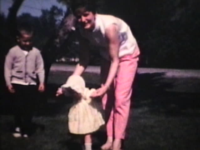 A cute family posing and playing in the front yard on a beautiful summer day. 