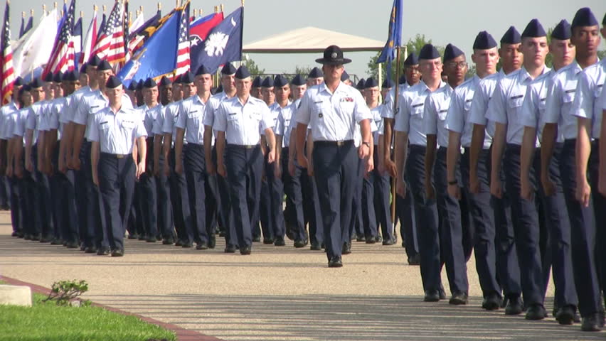 Video of USAF enlisted Basic Training graduates marching in review during graduation ceremony. Enlisted carrying flags being lead by a Drill Sgt.  Lackland AFB San Antonio, Texas. 