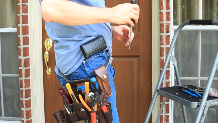 A man wearing a tool belt full of tools steps up onto a ladder to begin repairs on something on the porch.