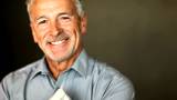 Closeup of cheerful mature man smiling over dark background