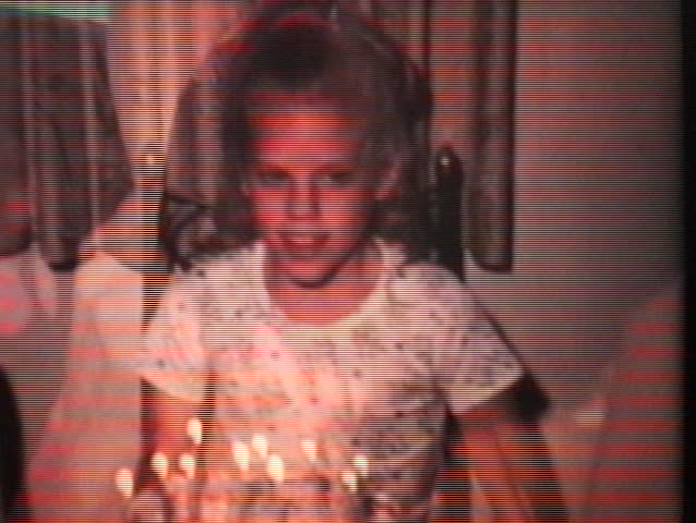 A cute little blond girl blows out the candles on her birthday cake as she celebrates turning ten years old.