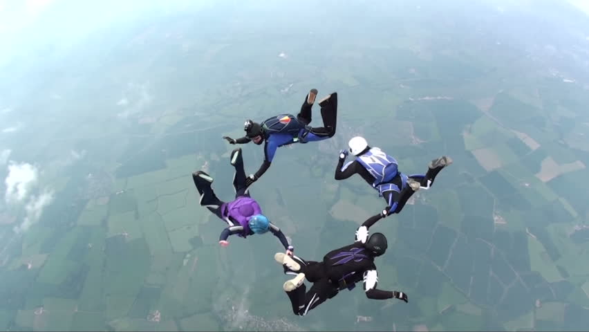 Four skydivers in freefall doing formations