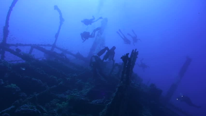 Low angle silhouette view of Scuba divers on the shipwreck SS Numidia, Brothers Islands, Red Sea, Egypt.