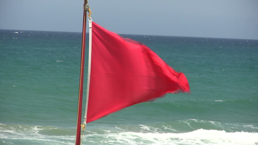Red flag indicating that it's forbidden to go swimming for the stormy sea. 
