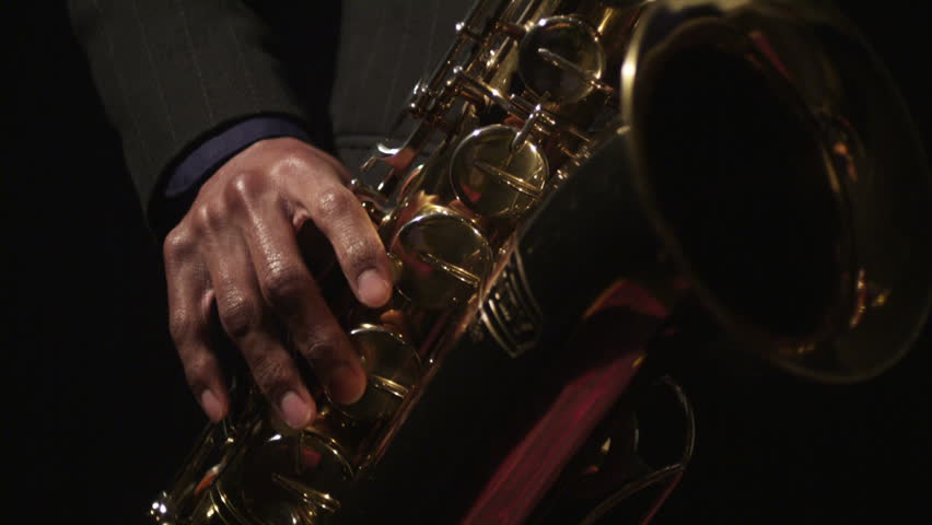 A young saxaphonist plays his instrument. 