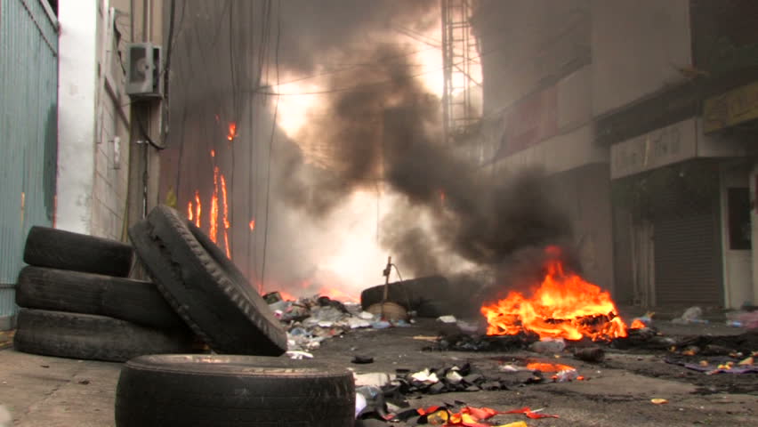 BANGKOK, THAILAND - April 19, 2010: Protesters set barricades built of tires on fire to create smoke screens seeking protection from government snipers