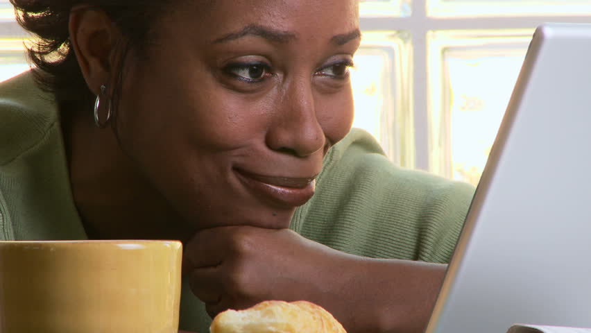Woman using laptop at breakfast time