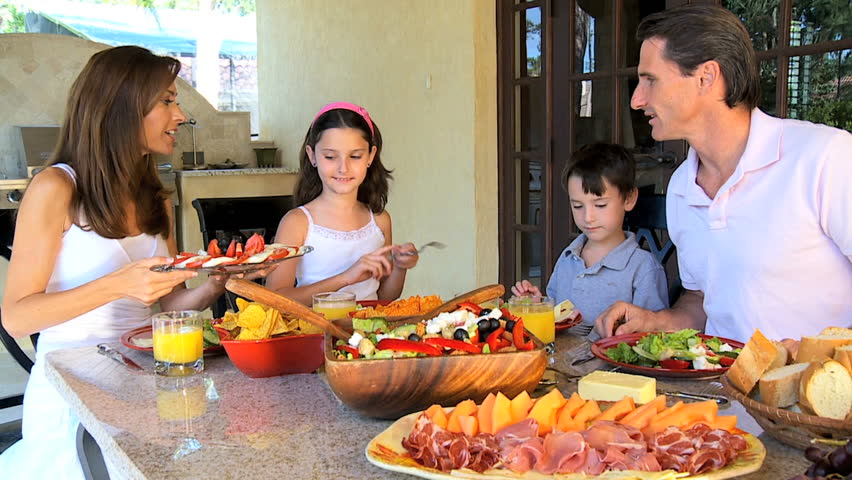 Attractive Caucasian family sitting at home sharing a healthy meal together 60FPS