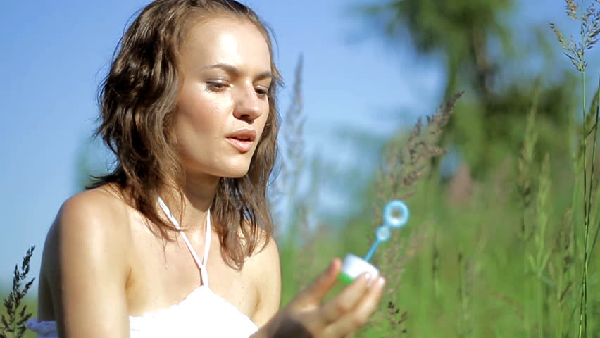 Young woman on a green meadow blowing bubbles, slow motion, shot at 60 fps - 720p