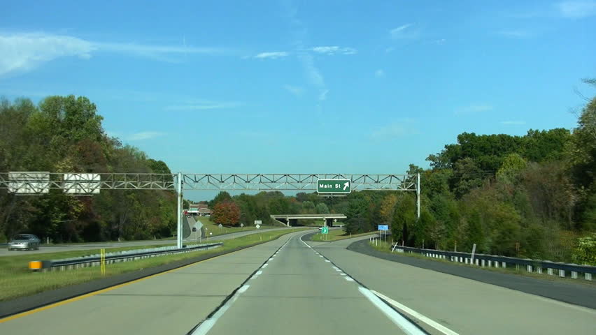 HD driving down a bypass with Main Street exit and overpass