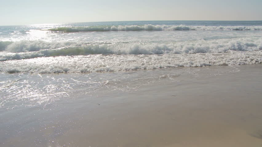 Couple laying by ocean side in lounge chairs startled by waves
