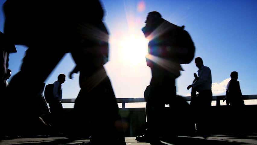 Low level shot of city commuters in silhouette & in slow motion filmed at 60FPS