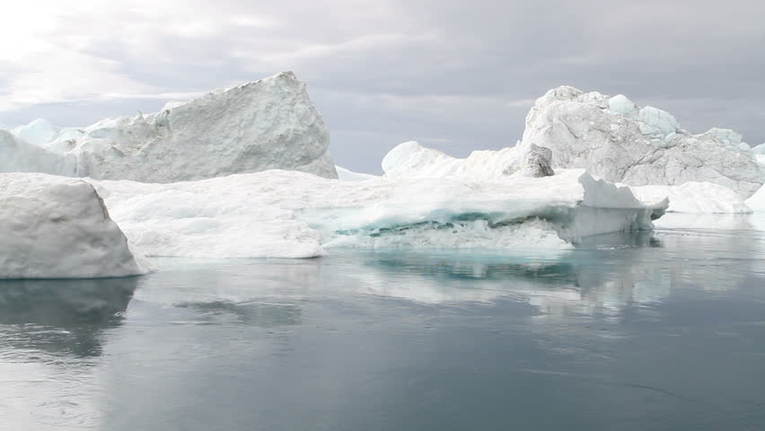 Calm moving water in front of some icebergs. This is the ice-fjord by Ilulissat, Greenland.
