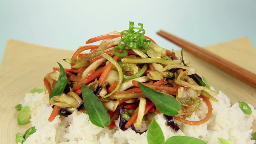 Soy sauce being poured over piping hot Asian vegetarian stir fry.