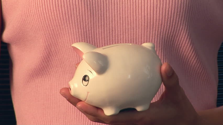 Woman putting money in piggybank