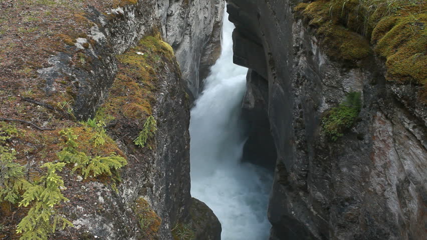 River gorge and waterfall Maligne Canyon, Banff National Park, Alberta, Canada. Rushing water pours through narrow gorge created by the forces of water. Popular vacation and naturalist destination.