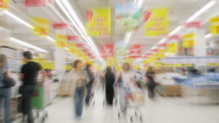 People with shopping carts in a supermarket. Motion blur. Time lapse.