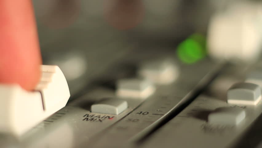 Live performance concert elements, including mixing console, stage lights, and speakers and guitar player.