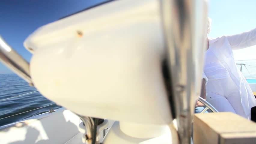 Healthy retired couple steering a course aboard their luxury sailing boat