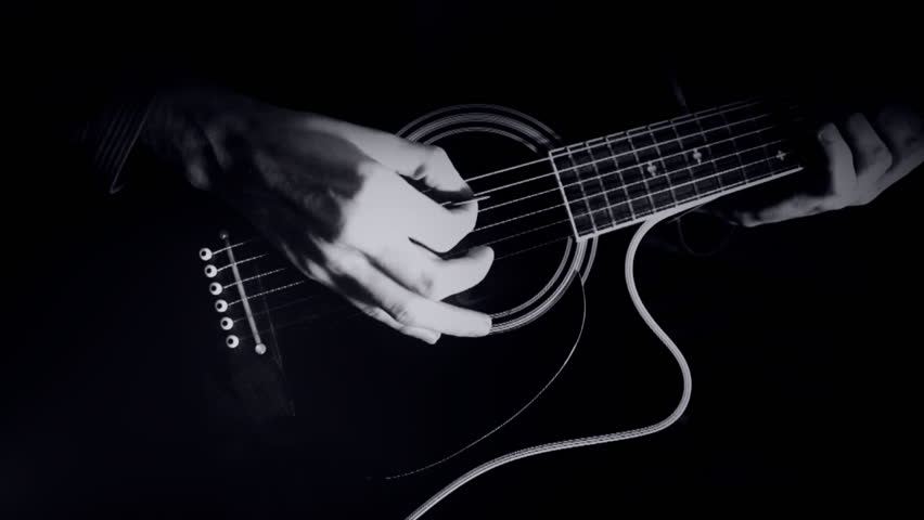 Noir style, man plays on guitar with a low-key black-and-white visual style.