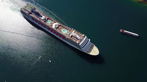 Aerial view of White luxury cruise ship docked in beautiful Caribbean sea close to the beach.