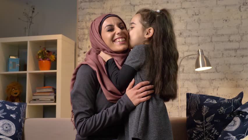 4k00 09a Little Girl Kisses Her Mother In A Hijab Sitting On The Couch