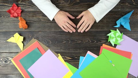 Hands Of Guy Make Origami Crane With Green Paper Top View Folding Paper Creating Figure