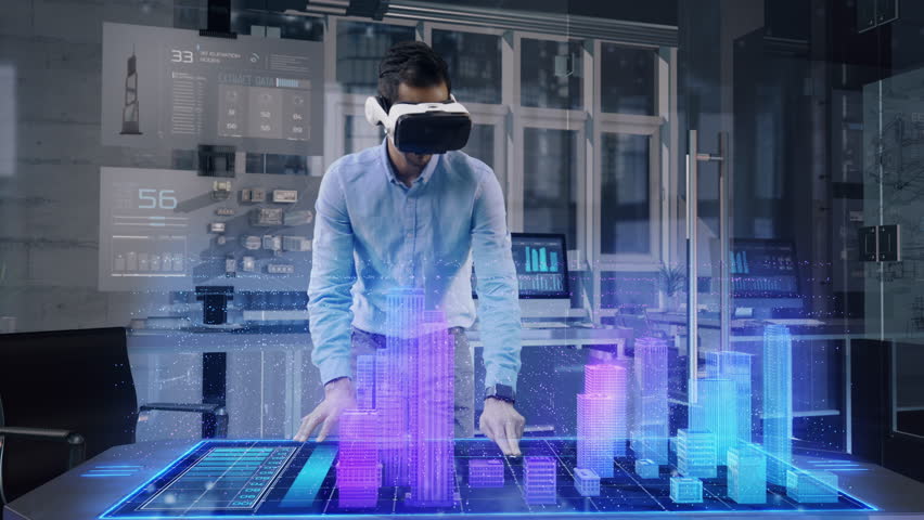 Professional Male Architect wearing Augmented Reality Headset makes gestures and redesigns 3D City Model. High Tech Office use Virtual Reality Modeling Software Application.