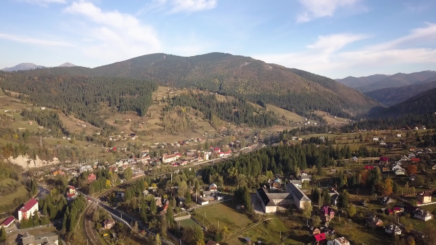 Landscape with houses, hills, and mountains in the distance image ...