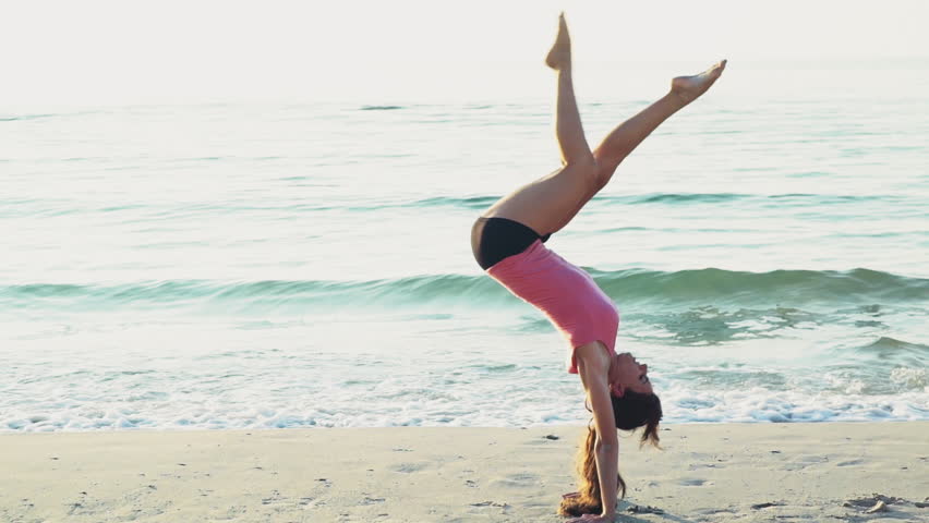 Two Women Doing Cartwheels On The Beach In Slow Motion Stock Footage ...