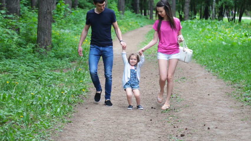 Mom And Young Daughter And Dad A Young Family On A Walk In The