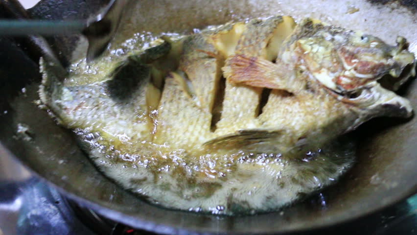 Stir Frying Tilapia Fish In Kitchen Cooking Over Makeshift Fire Pit