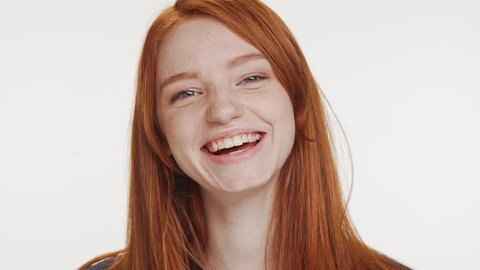 480px x 270px - Close footage of young caucasian red haired teenage girl smiling laughing  on white background in slowmotion