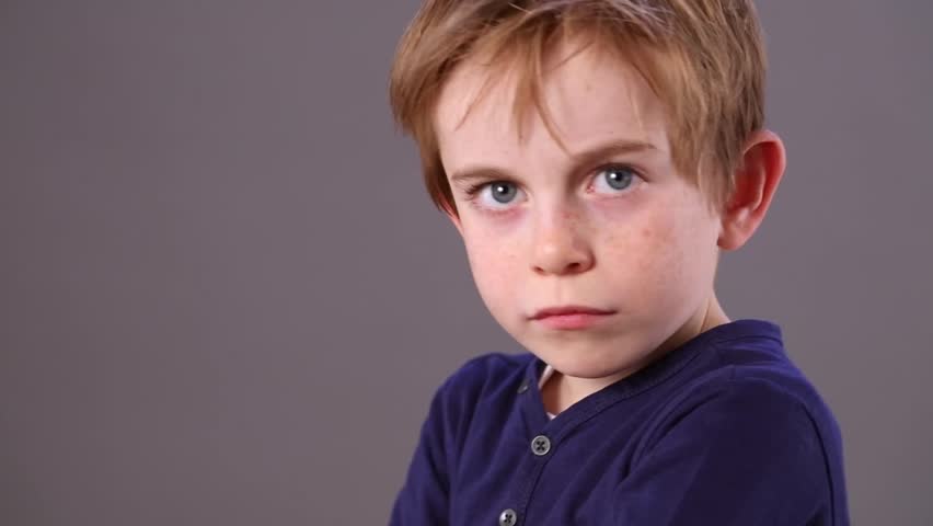 Closeup Of An Angry Little Boy With Freckles And Blue Eyes Playing Mean ...