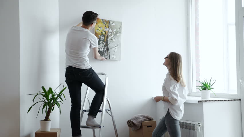 Cheerful Couple Hanging Picture On Stock Footage 100 Royalty Free 24327911 Shutterstock