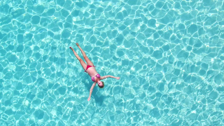 Aerial View Of An Attractive Woman In A Bikini Floating In Crystal ...