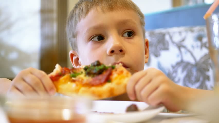 Close Up Of Little Cute Boy Eating Pizza. Selective Focus On Pizza With ...