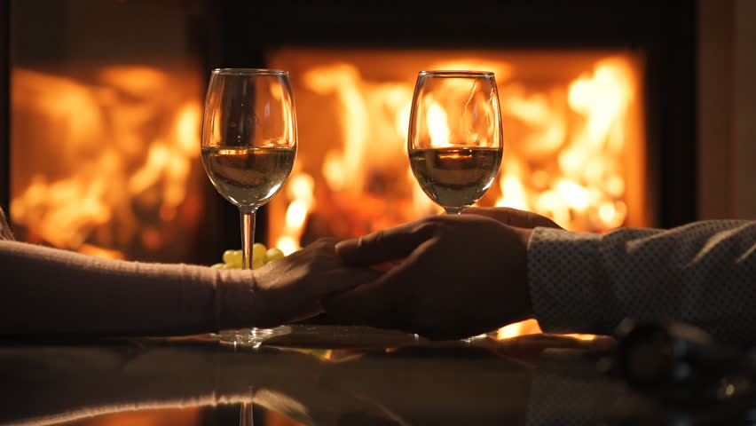 Young Couple Have Romantic Dinner With Wine Over Fireplace Background