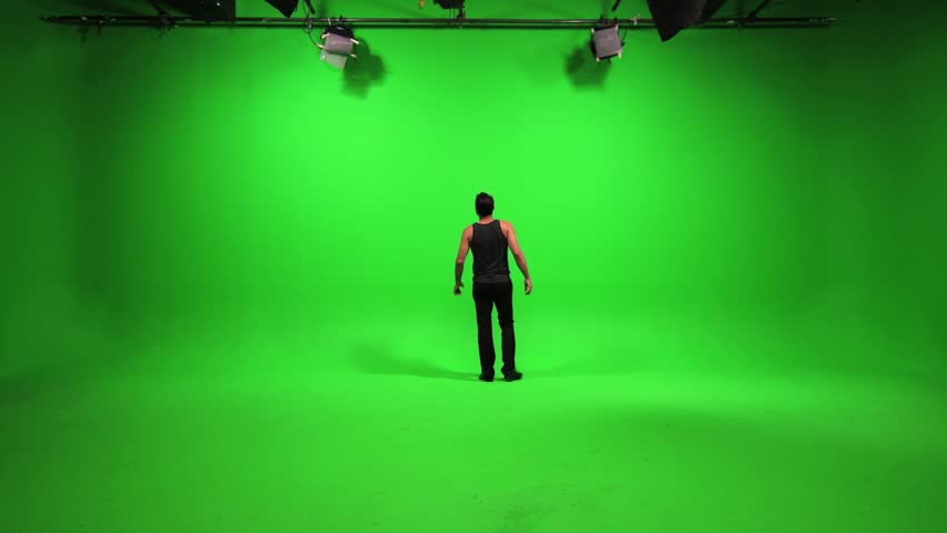 Portrait Of Young Man Standing Against Green Screen. Male Person People