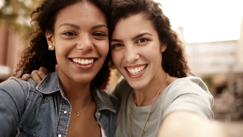 Mixed Race Girl Friends Taking Selfie And Smile Into Camera Stock ...