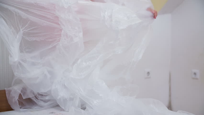 Person Cover Furniture With Stock Footage Video 100 Royalty Person Cover Furniture With Plastic Sheet In Slow Motion Close Up Of Stretching Out For Protection Against Color Drops While Painting